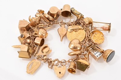 Lot 632 - Gold charm bracelet with a collection of gold and yellow metal charms to include an Edward VII gold half sovereign
