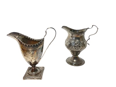 Lot 186 - George III silver milk / cream jug of helmet form with brite cut engraved decoration, raised on a square pedestal foot, (London 1792), together with another George III silver milk / cream jug of...