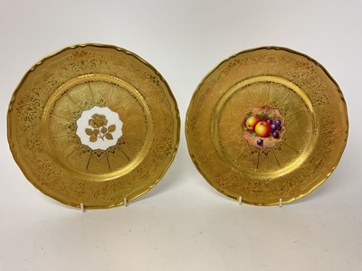 Lot 48 - Two Royal Worcester plates, the first with central panel painted with fruit, signed by Freeman, on gilt-tooled ground, the other with central gilt-tooled rose, marks to bases, each 27cm diameter...