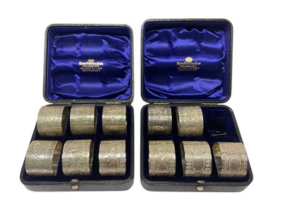 Lot 304 - Eleven silver napkin rings in two fitted boxes