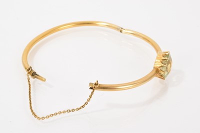 Lot 517 - Victorian gold hinged bangle with a pale green stone in claw setting
