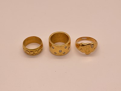 Lot 25 - Three gold rings to include an 18ct gold and diamond signet ring, 18ct gold wedding ring and a gold/yellow metal and diamond set band