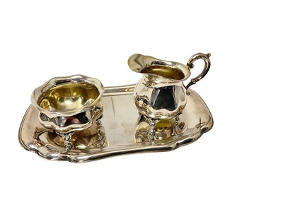 Lot 140 - German silver milk, sugar bowl of baluster form and matching tray (marked on bases). All at approximately 8ozs. Tray 20.5cm across. (3)