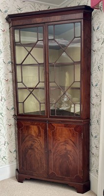 Lot 1353 - Regency mahogany corner cabinet inlaid with stringing enclosed by a pair of glazed doors above a slide and a pair of cupboard doors, on bracket feet, 106.7cm wide