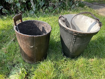 Lot 1461 - Early carved wooden bucket, carved out from a single log, with single handle and dog portrait to side, height 33cm, and a 19th century leather bucket. (2)