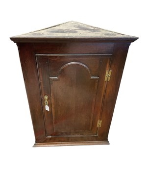 Lot 1468 - George III oak and fruitwood crossbanded hanging corner cupboard, with shaped shelves enclosed by an arched panel door, 69cm wide x 35cm deep x 96cm
