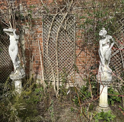 Lot 1364 - Two Classical style garden statues in the form of semi-clad female figures, on tapered and fluted columns and circular bases, 176cm high overall
