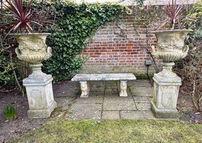 Lot 1365 - Pair of Classical style garden urns, each of twin handled campagna form with moulded fruit and foliate swags, on square plinths, 131cm high overall