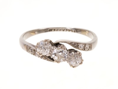 Lot 553 - Antique diamond three stone ring with three old cut diamonds in crossover claw setting with further old cut diamonds to the shoulders in platinum setting on 18ct white gold shank
