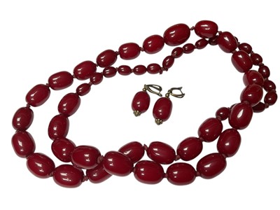 Lot 314 - Vintage simulated cherry amber graduated bead necklace, approximately 96cm long, together with a pair of matching earrings with brass fittings