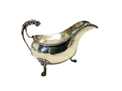 Lot 193 - George V silver sauce boat with gadrooned border and lion mask handle, raised on three paw feet, (Birmingham 1914), maker James Woods & Son, all at approximately 6.5ozs, 15.4cm in length.