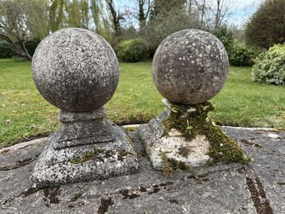 Lot 1501 - Pair of weathered garden spheres on stepped square bases, 45cm high, the bases 32cm square