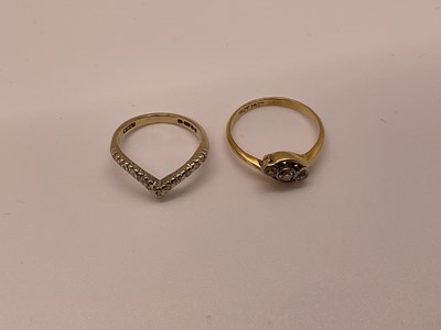 Lot 21 - 1920s three stone ring in 18ct cross-over setting and a 9ct gold diamond wishbone eternity ring (2)