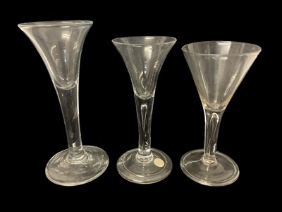 Lot 57 - Six Georgian drinking glasses, including two with teared stems and folded feet, one plain stem with drawn trumpet bowl, one etched with vines and wheat, an ale flute with faceted stem and a cord...