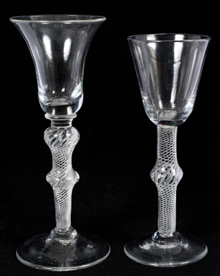 Lot 58 - Two 18th century multi spiral air twist wine glasses, the first with round funnel bowl on a single-knopped stem, the other with bell bowl on a double-knopped stem, 15cm and 16.5cm high