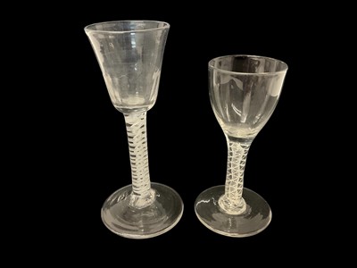Lot 59 - Two 18th century double series opaque twist wine glasses, the first with an ovoid bowl, 12.75cm high, the second with fluted round funnel bowl, 15.25cm high