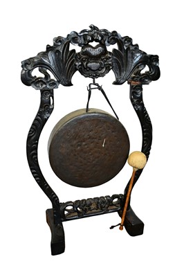 Lot 1380 - Early 20th century Chinese dinner gong on stand, with carved frame suspending the 39cm gong and beater, 99cm high