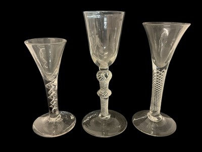 Lot 63 - Three mid 18th century air twist wine glasses, including one corkscrew twist, and two multi spiral, 13.75cm to 17.75cm high (3)