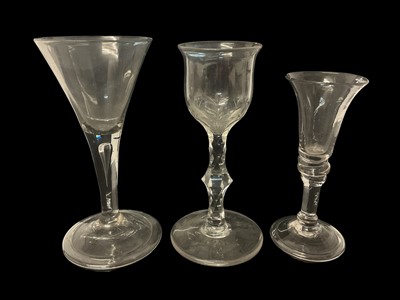 Lot 64 - Three 18th century wine glasses, including one with drawn trumpet bowl and teared stem, one with cut ogee bowl and faceted stem, and one other, 13cm to 15.5cm high (3)