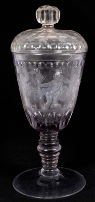 Lot 26 - Large Bohemian cut and engraved glass goblet and domed cover, circa 1730, well engraved with five putti around the body struggling with a heavy swag of pomegranates, grapes and other fruit, be...