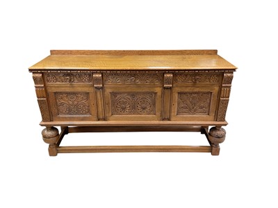 Lot 1411 - Suite of Jacobean revival blond oak furniture by Maples, comprising oak drawer leaf table, set of four chairs and sideboard, all well carved