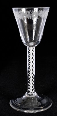 Lot 24 - Opaque twist wine glass, circa 1760, with tapering funnel bowl, engraved at the rim with flowers and foliage, on a straight double series opaque twist stem and domed foot, 15cm high