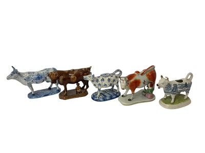 Lot 127 - Four 19th century ceramic cow creamers, of various type, and a Delft model of a cow