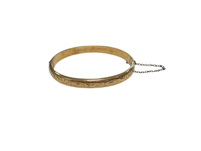 Lot 220 - 9ct gold hinged bangle with engraved scroll decoration (Chester 1953)