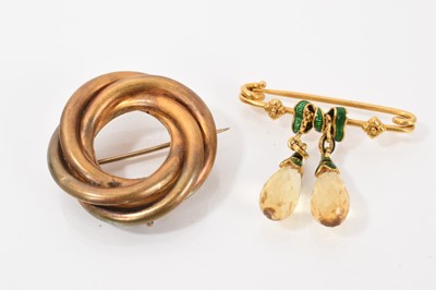 Lot 584 - Edwardian briolette cut citrine pendant brooch and a Victorian yellow metal wreath/knot brooch (2)