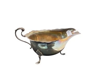 Lot 106 - George V silver sauce boat of helmet form, raised on three hoof feet, (Birmingham 1929), makers mark rubbed, 15cm in length, 3ozs.