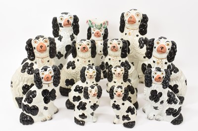 Lot 185 - Six pairs of Victorian Staffordshire pottery black and white spaniels, each numbered one to six, the largest 30.5cm high, together with a Staffordshire spaniel jug (13)