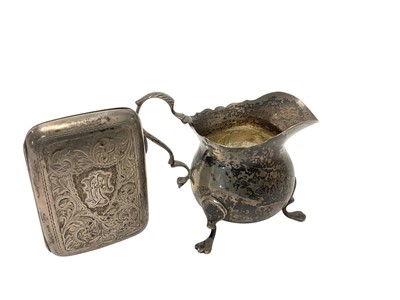 Lot 102 - Edwardian silver cream jug of baluster form, raised on three hoof feet, (Chester 1906), together with a silver cigarette case (Chester 1921) , all at 5.5ozs.