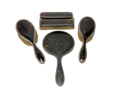 Lot 100 - George V silver and tortoiseshell five-piece dressing table set, (London 1925).