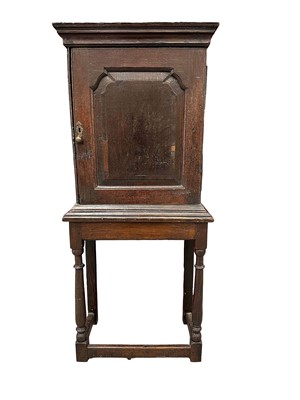 Lot 1549 - 18th century and later oak spice cupboard on stand, with moulded cornice above a panelled door enclosing nine various drawers, the base on turned supports joined by stretchers, 131.5cm high x 58...