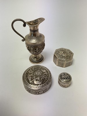 Lot 5 - Indian white metal jug decorated with roundels with Gods in relief, 13cm high, together with three Eastern white metal boxes with various relief decoration, approx 9.64 troy oz in total