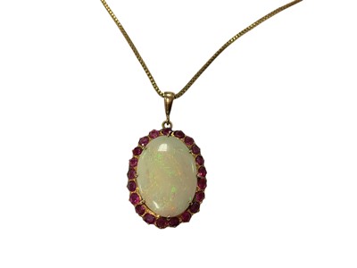 Lot 239 - Large oval opal and synthetic ruby pendant in a yellow metal mount on a gold plated box link chain