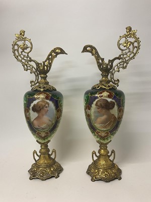 Lot 11 - Impressive pair of Edwardian porcelain and gilt metal ewers, the porcelain body with reserves depicting female portraits, on green ground, 70cm.