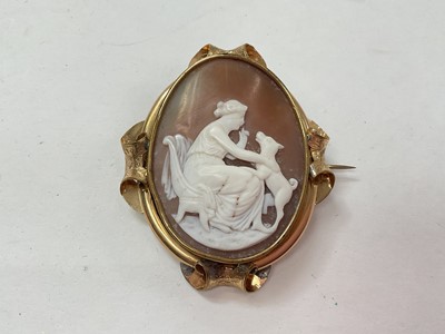 Lot 1069 - Victorian carved shell cameo depicting a seated woman with a dog, in a gilt metal brooch mount
