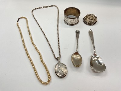 Lot 1011 - Silver napkin ring, two silver spoons, silver brooch, white metal locket on rope twist chain and a simulated pearl necklace