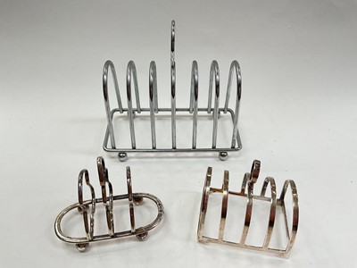 Lot 1024 - Silver four division toast rack, silver two division toast rack and a silver plated six division toast rack (3).