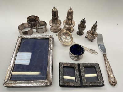Lot 1018 - Group of silver to include condiments, photograph frames, three napkin rings, sifter spoon and a silver handled knife
