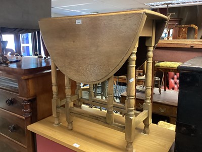 Lot 1305 - Honey oak oval drop flap table on turned supports joined by stretchers