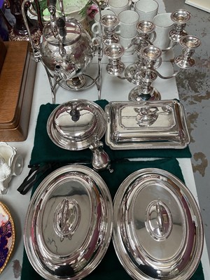 Lot 319 - Group of silver plate to include a spirit kettle on stand, pair of three branch candelabrum, pair of oval tureens with covers, two other tureens and a milk jug