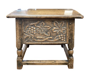 Lot 1285 - Carved oak stool with hinged lid, leaf and berry decoration on turned and block supports joined by stretchers, 56cm wide, 41cm deep, 50cm high