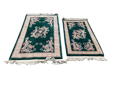Lot 1332 - Two Chinese rugs with floral decoration on green ground, 153cm x 90cm and 122cm x 68cm together with another rug, 131cm x 68cm (3)