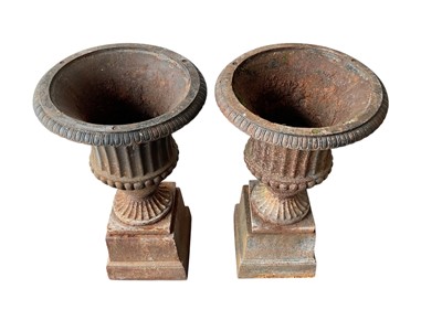 Lot 1397 - Pair of antique cast iron garden urns on stands. Approximately 69cm tall by 38cm wide.