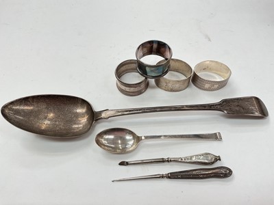 Lot 1156 - Four silver napkins rings, silver teaspoon, white metal serving spoon and two silver handled items