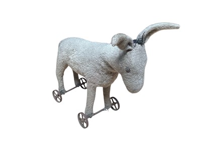 Lot 1818 - Early grey mohair pull-a-long donkey, metal axis and wheels. 45cms nose to tail tip approximately.
