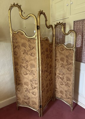 Lot 1584 - Late 19th century French gilt wood three fold screen, each panel of graduated form with glazed top section and fabric panels below, 184cm high