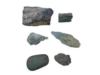 Lot 2418 - Group of four ancient stone hand tools, including one with an old paper label to the back dating it to 15,000 to 20,000 years old, together with two pieces of fossilised wood